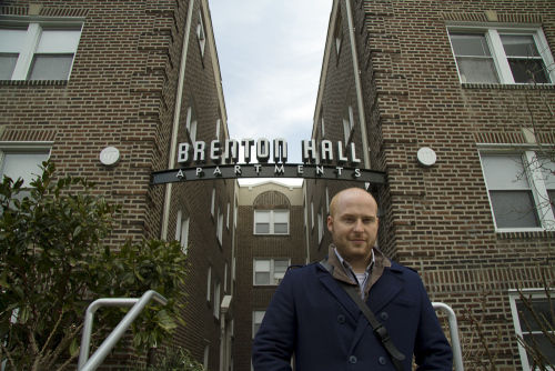 Josh Korwin in front of Brenton Hall Apartments sign, Narberth, Pennsylvania
