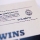 Close-up of tiny text and blurred-out \"WIAA\" logo for the \"Wedding Invitation Association of America.\"